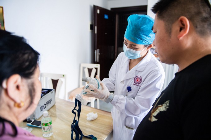 3在湖南省长沙市某小区，湖南省人民医院的医护人员（中）给居家老人家属讲解如何清理呼吸面罩（2021年5月8日摄）。新华社记者 陈思汗 摄.jpg